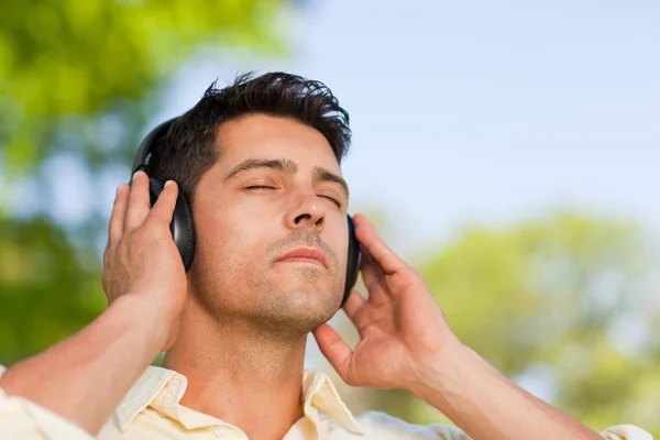 Man listening to music in the park — Stock Photo, Image