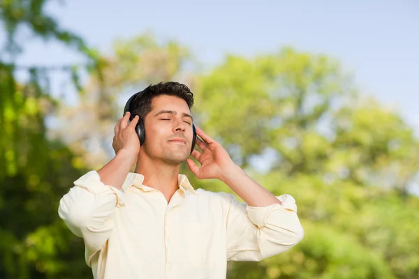 남자는 공원에서 음악을 듣고 — 스톡 사진