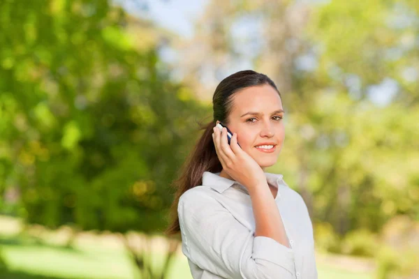 Woman phoning in the park — Stock Photo, Image