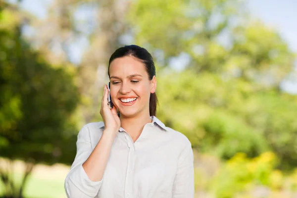 Junge Frau telefoniert im Park — Stockfoto