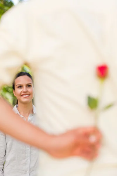 Homem feliz oferecendo uma rosa para sua namorada — Fotografia de Stock