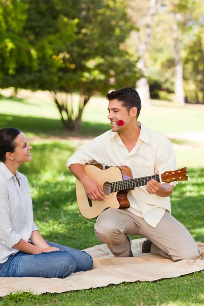 Muž hraje na kytaru pro svou přítelkyni — Stock fotografie