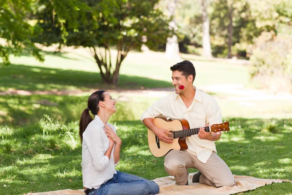 Человек играет на гитаре для своей девушки — стоковое фото