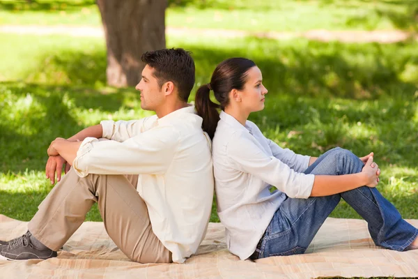 Пара сидящих спиной к спине в парке — стоковое фото