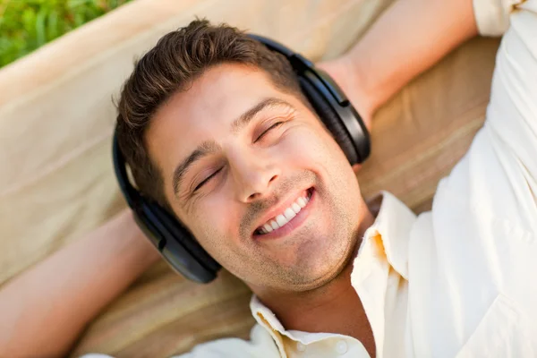 Junger Mann hört Musik im Park — Stockfoto
