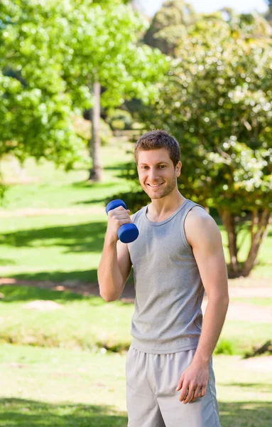 Молодой человек делает упражнения в парке — стоковое фото