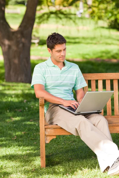 Przystojny mężczyzna pracujący na swoim laptopie — Zdjęcie stockowe