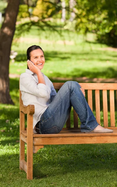 Mladá krásná žena telefonují na lavičce — Stock fotografie
