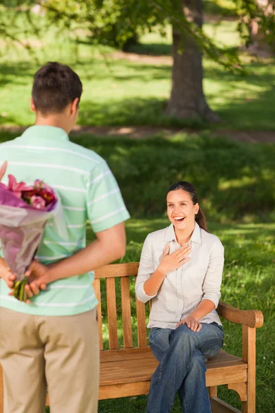 Młody człowiek oferuje kwiaty żonie — Zdjęcie stockowe