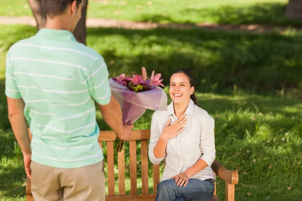 Giovane uomo che offre fiori a sua moglie — Foto Stock