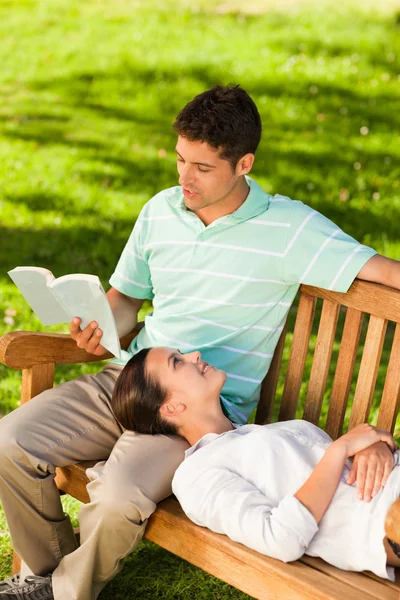 Hombre leyendo un libro con su novia — Foto de Stock