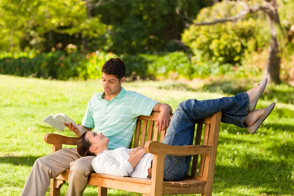 Hombre leyendo un libro con su novia — Foto de Stock