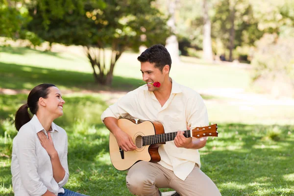Hombre tocando la guitarra para su novia — Foto de Stock