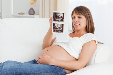 Close up of a pregnant woman looking at her baby's ultrasound sc clipart