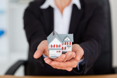 Feminine hands holding a miniature house clipart