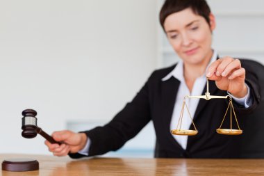 Serious judge with a gavel and the justice scale clipart