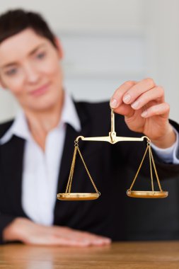 Serious woman holding the justice scale clipart