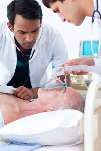Médicos multi-étnicos ressuscitam um paciente idoso — Fotografia de Stock