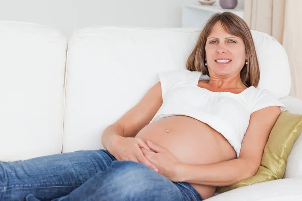 Vackra gravid kvinna poserar liggande — Stockfoto