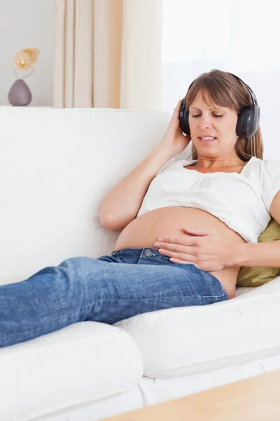 Porträt einer glücklichen Schwangeren, die Musik hört — Stockfoto