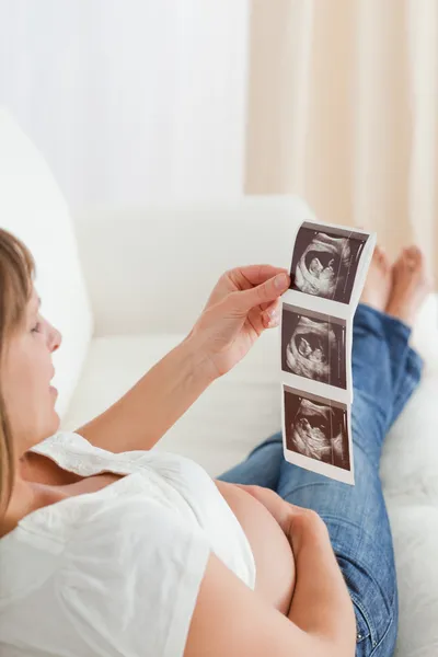 Добре виглядає вагітна жінка, дивлячись на сонографію — стокове фото