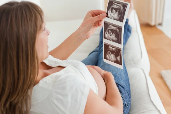 Γοητευτική έγκυος γυναίκα κοιτάζοντας ένα υπερηχογράφημα — Φωτογραφία Αρχείου