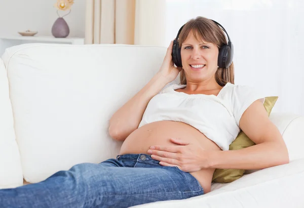 Nahaufnahme einer schwangeren Frau, die Musik hört — Stockfoto