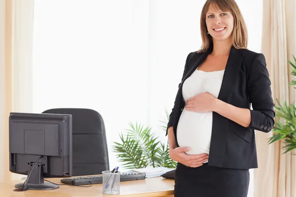 Atrakcyjna kobieta w ciąży pozowanie stojąc — Zdjęcie stockowe