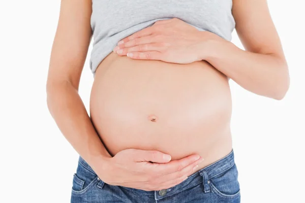 Nahaufnahme einer jungen schwangeren Frau, die ihren Bauch streichelt, während — Stockfoto