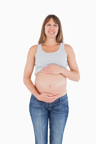 Attraktive schwangere Frau streichelt ihren Bauch im Stehen — Stockfoto