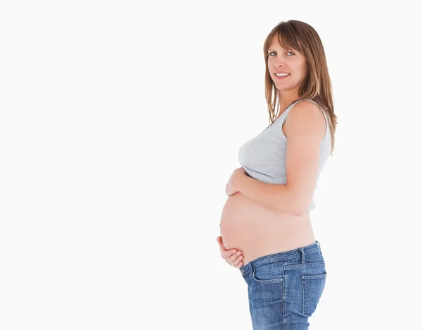 Widok z boku piękna kobieta w ciąży, pieszcząc jej brzuch whil — Zdjęcie stockowe
