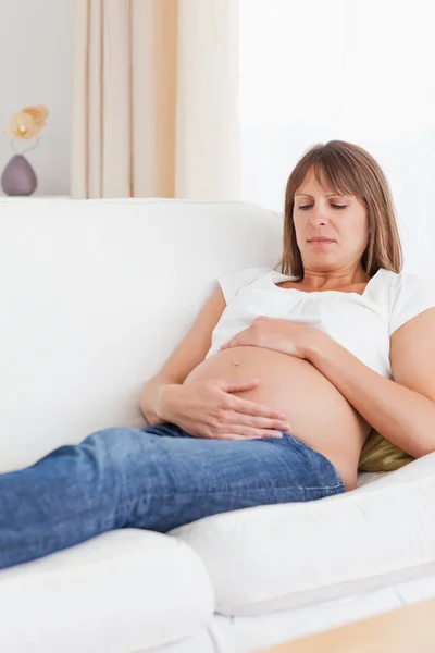 Портрет беременной женщины, лежащей на диване — стоковое фото