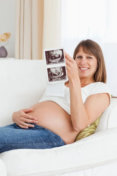 Portrait of a pregnant woman looking at her baby's ultrasound sc — Stock Photo, Image