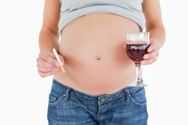 Έγκυος γυναίκα, κρατώντας ένα ποτήρι κόκκινο κρασί, ενώ στέκεται — Φωτογραφία Αρχείου