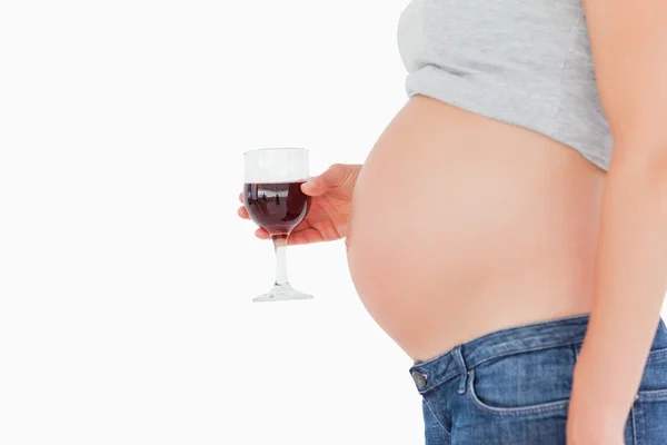 Ver perfil de una mujer embarazada sosteniendo una copa de vino tinto — Foto de Stock