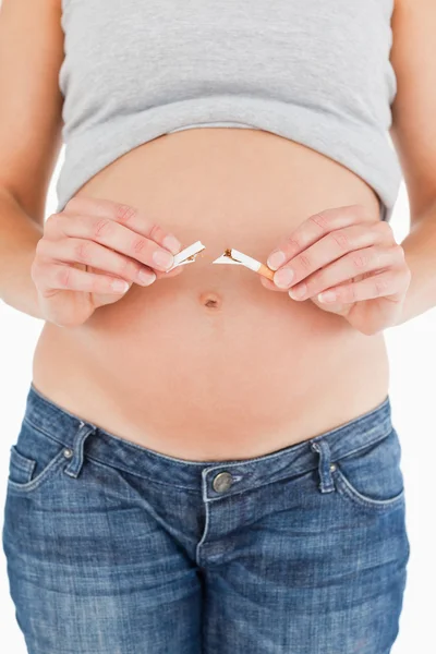 妊娠中の女性が立っている間壊れたたばこを保持 — ストック写真
