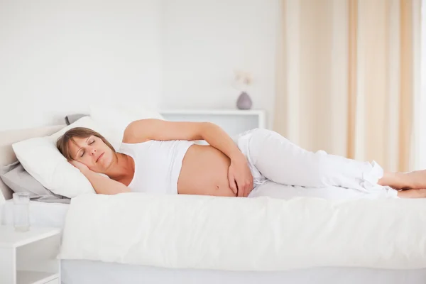 Vackra gravid kvinna avkopplande liggande på hennes säng — Stockfoto