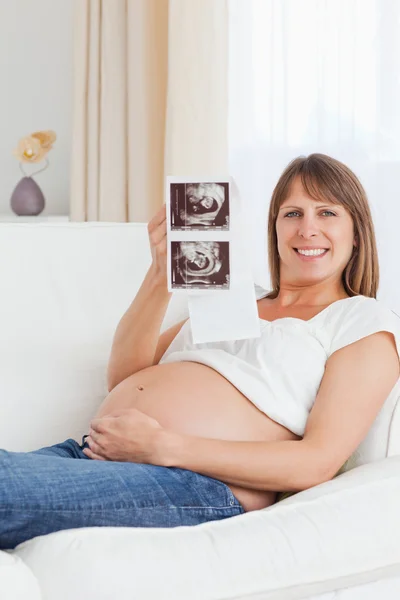 Portret van een zwangere vrouw toont haar baby's echografie scannen — Stockfoto