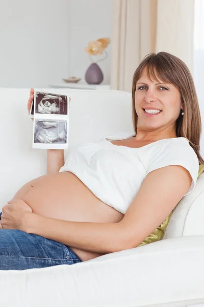 Gros plan d'une femme enceinte montrant l'échographie de son bébé — Photo
