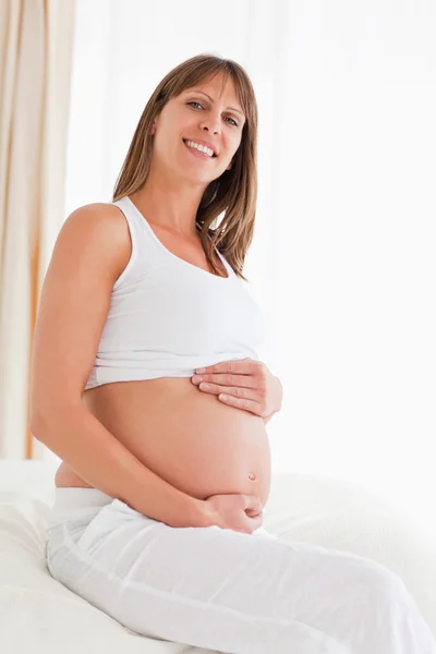 Портрет прекрасной беременной женщины, позирующей, сидя на б — стоковое фото