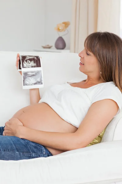 Κοντινό πλάνο μια έγκυος γυναίκα κοιτάζοντας sc υπερηχογράφημα του μωρού — Φωτογραφία Αρχείου