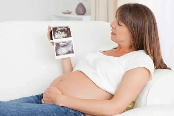 Щаслива вагітна жінка дивиться на ультразвукове сканування дитини — стокове фото
