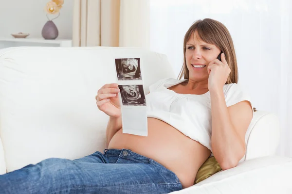 Mulher grávida feliz falando sobre o ultra-som de seu bebê — Fotografia de Stock