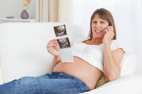 Close-up de uma mulher grávida falando sobre o ultra-som do bebê — Fotografia de Stock