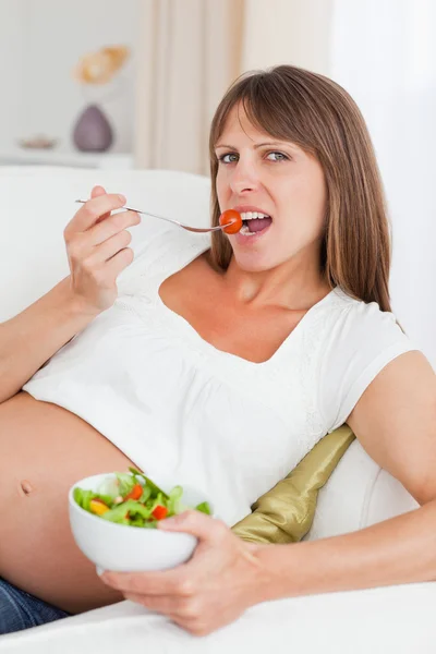 Zblízka těhotné ženy jíst salát — Stock fotografie