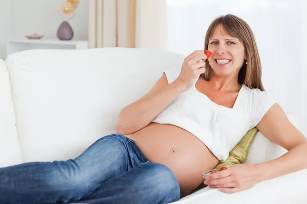 Gravid kvinna äter jordgubbar — Stockfoto
