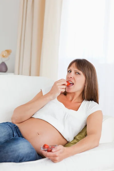 Gut aussehende Schwangere isst Erdbeeren — Stockfoto