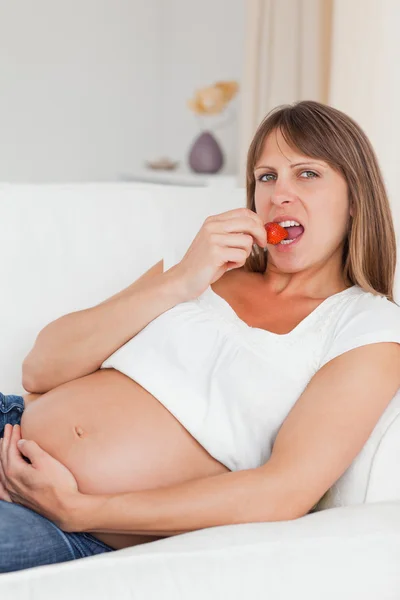 Attraktive schwangere Frau isst Erdbeeren — Stockfoto