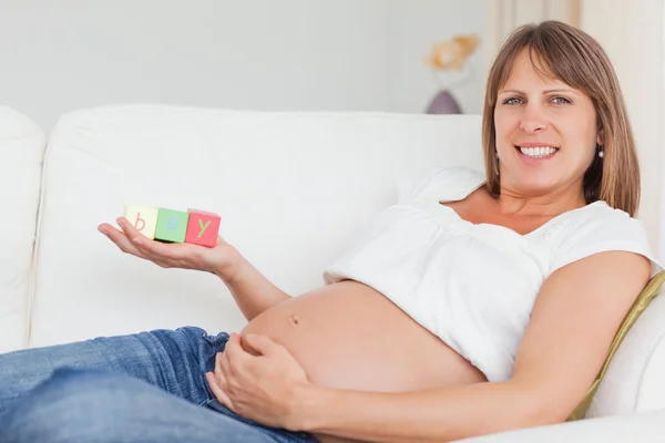 Schöne schwangere Frau spielt mit Holzklötzen und mit t — Stockfoto