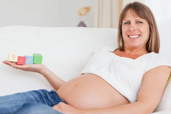 Dobře vypadající těhotná žena s dřevěných bloků a havin — Stock fotografie